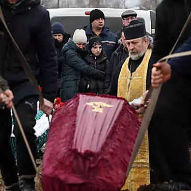 Χλωμή από τη θλίψη, μια Ουκρανή θάβει την οικογένειά της