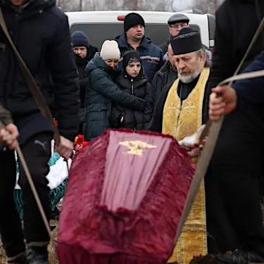 Χλωμή από τη θλίψη, μια Ουκρανή θάβει την οικογένειά της