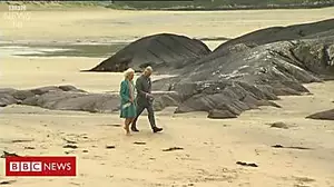 Duchess kicks off her shoes on the sand