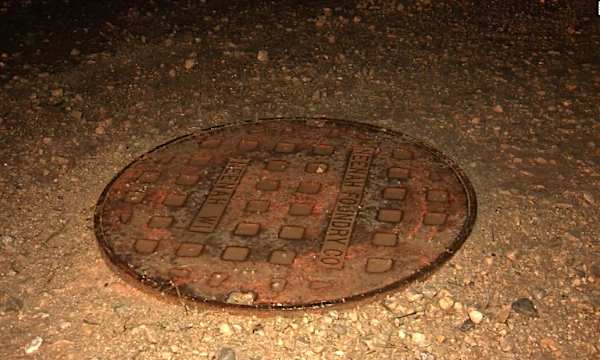 A finger poking through a manhole cover alerts rescuers to a boy swept away by floodwaters