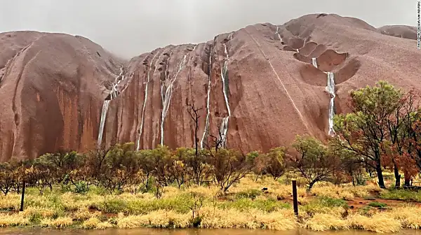 Water cascades down Uluru after heavy rains batter northern Australia