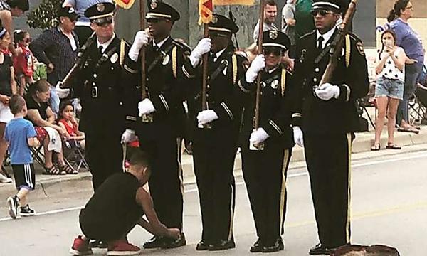 An honor guard member's shoelaces became untied during a parade. Then this 10-year-old boy leaped into action