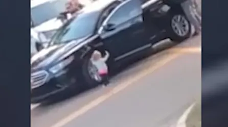 Niña con las manos en alto camina hacia la policía