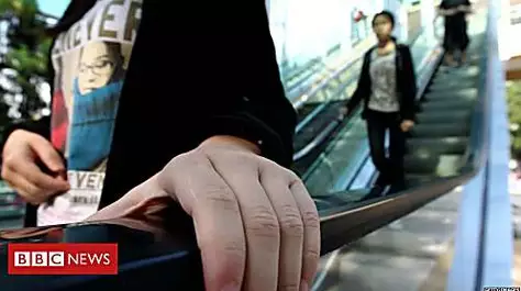 Award for woman cuffed for not holding escalator