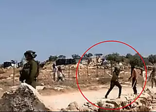 Masked Israelis filmed throwing stones at Palestinians while soldiers stood by