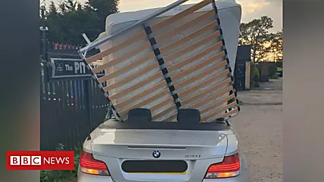 BMW driver wedges bed into the back of convertible