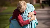 A mom of an ICU nurse covered her daughter with a bed sheet to give her a hug