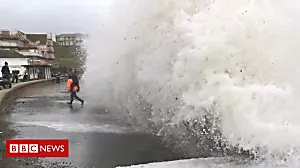 Man and child almost swept into sea by wave